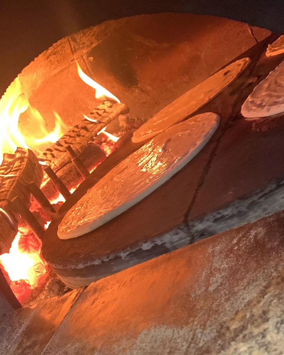 Pâtes à pizza devant le feu du four à bois